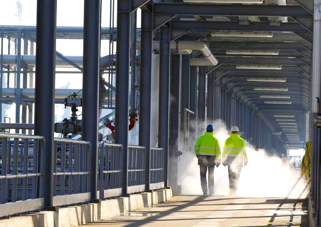 men walking across pipeline bridge