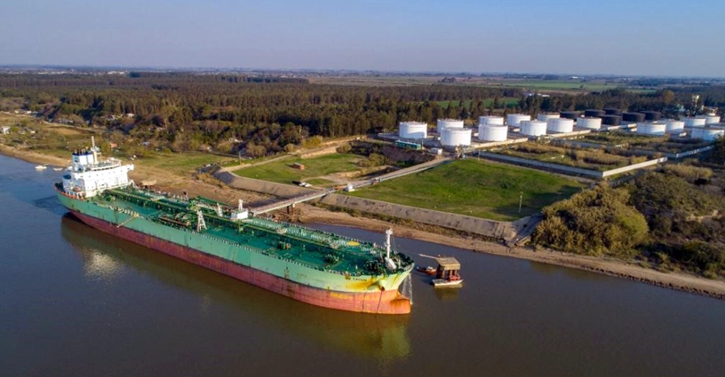 cargo ship docked near storage tanks